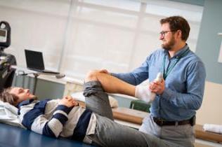 理疗师帮助病人进行膝关节运动